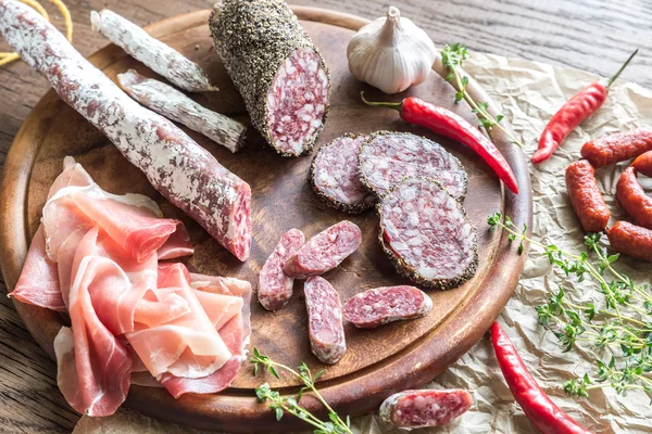 Different kinds of sausage on the wooden background — Stock Photo, Image