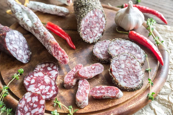 Skivor av saucisson, fuet och salami i trä styrelsen — Stockfoto