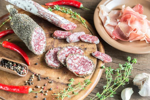 Scheiben Saucisson, Marmelade und Salami auf dem Holzbrett — Stockfoto