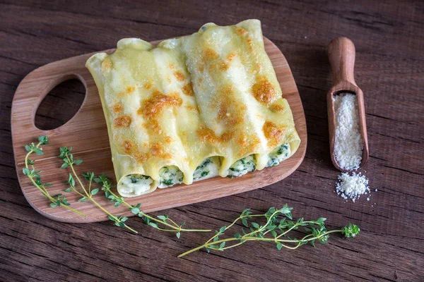 Cannelloni avec ricotta et épinards sur la planche en bois — Photo