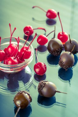 Chocolate and cocktail cherries on the glass clipart