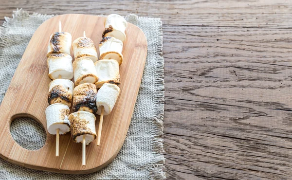 Espetos de marshmallow na tábua de madeira — Fotografia de Stock