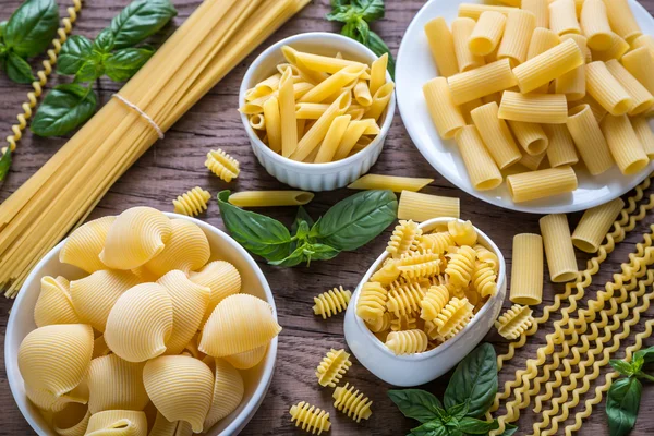 Olika typer av pasta på trä bakgrund — Stockfoto