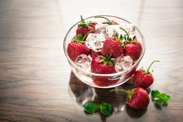 Čerstvé jahody s kostkami ledu v skleněná mísa — Stock fotografie