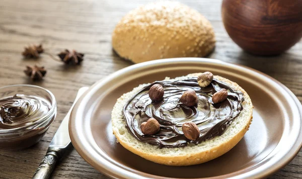 Sesame bun with chocolate cream and nuts — Stock Photo, Image