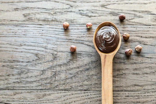 Houten lepel van chocolade crème met hazelnoten — Stockfoto