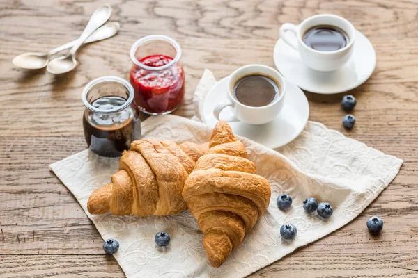 Croissants con arándanos frescos y dos tazas de café —  Fotos de Stock