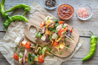 Ahşap tahta üzerinde ızgara sebze şişleri