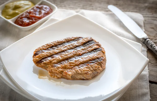 Sığır eti biftek beyaz kare plaka üzerinde — Stok fotoğraf