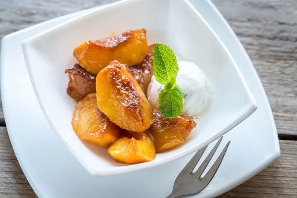 Caramelized peaches with vanilla ice cream — Stock Photo, Image