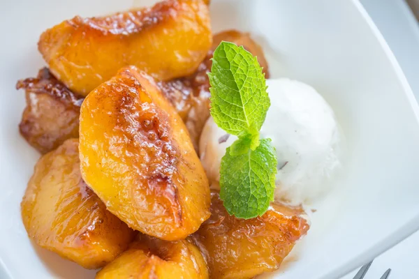 Карамельные персики с ванильным мороженым — стоковое фото