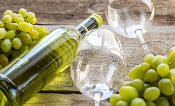 Бутылка белого вина с кучей винограда — стоковое фото