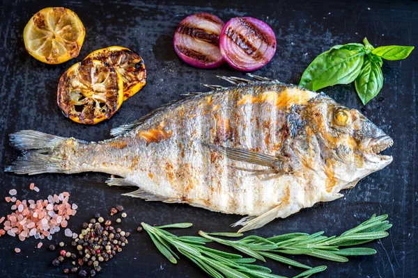 Gegrilde dorada vis met verse groenten en kruiden — Stockfoto