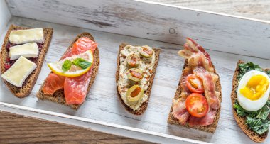 Bruschetta ahşap tepsi üzerinde farklı Topingler ile