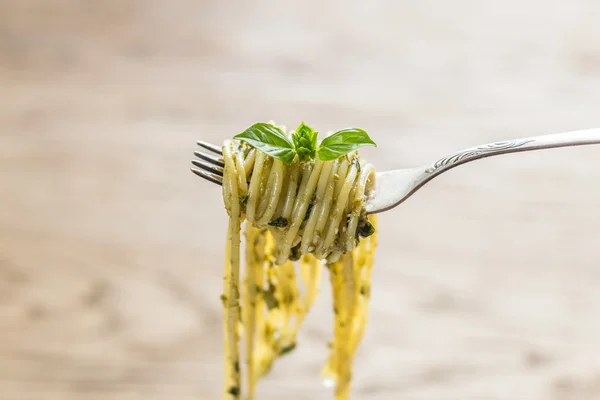 Spaghetti med pesto sås och basilika blad på gaffeln — Stockfoto