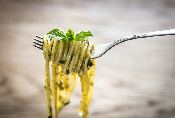 Spaghetti met pesto saus en basilicum blad aan de vork — Stockfoto