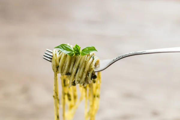 Spaghetti met pesto saus en basilicum blad aan de vork — Stockfoto