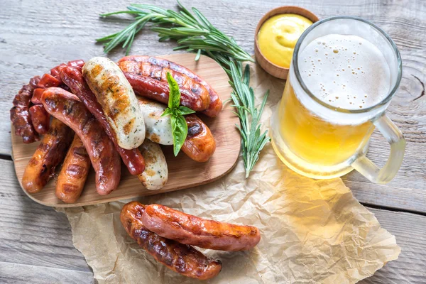 Salsichas grelhadas com copo de cerveja — Fotografia de Stock