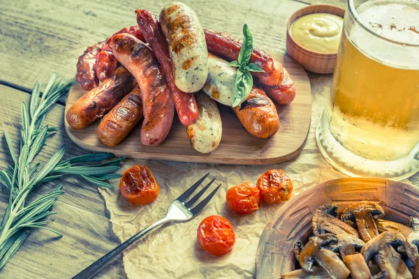 Embutidos a la parrilla con vaso de cerveza —  Fotos de Stock