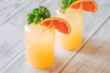 Cool citrus tones and mint freshness create bright, fizzy harmony against rustic wooden background