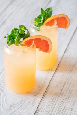 Cool citrus tones and mint freshness create bright, fizzy harmony against rustic wooden background