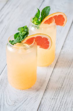 Cool citrus tones and mint freshness create bright, fizzy harmony against rustic wooden background