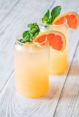 Cool citrus tones and mint freshness create bright, fizzy harmony against rustic wooden background