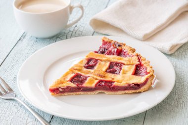 Golden crust and ruby filling glow beside warm coffee, evoking cozy morning indulgence