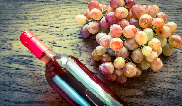 Garrafa de vinho rosa com molho de uva — Fotografia de Stock