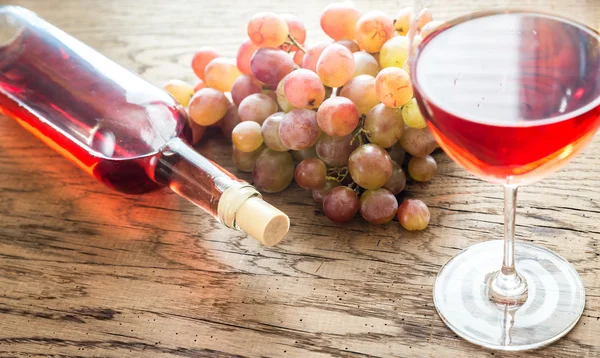 Glass of rose wine with bunch of grape — Stock Photo, Image