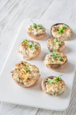 Toprak mantarlar beşikte kremalı sarımsak dolarken sıcak dokular zengin rahatlatıcı lezzeti ön plana çıkarıyor.