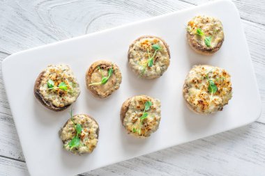 Toprak mantarlar beşikte kremalı sarımsak dolarken sıcak dokular zengin rahatlatıcı lezzeti ön plana çıkarıyor.