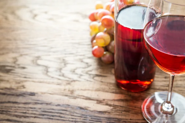 Склянка трояндового вина з гроном винограду — стокове фото