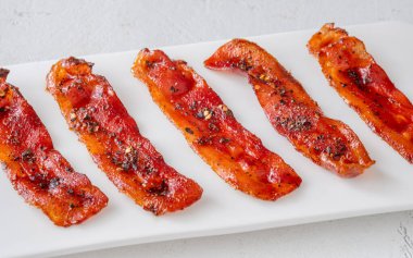 Çatlamış biberli tatlı pastırma ve temiz modern yüzeyde kırmızı biber taneleri.