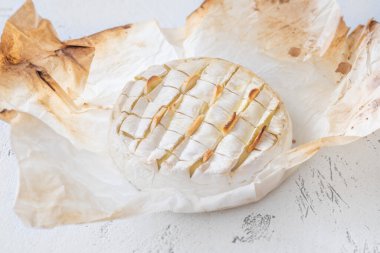 Sıcak eritilmiş peynir sarımsakla dolu ve zengin bir köy konforu yaratıyor.