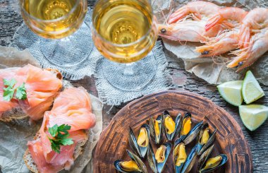 Deniz ürünleri ile iki bardak beyaz şarap ahşap tablo