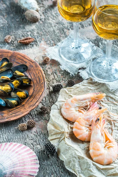 Frutos do mar com dois copos de vinho branco na mesa de madeira — Fotografia de Stock