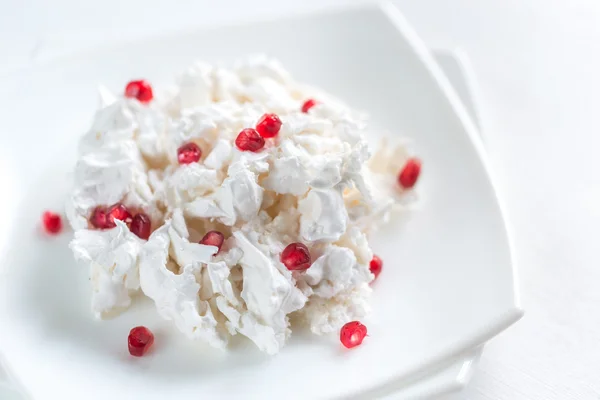 Portion of meringue with pomegranate seeds — Stock Photo, Image