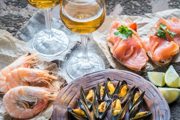 Meeresfrüchte mit zwei Gläsern Weißwein auf dem Holztisch — Stockfoto