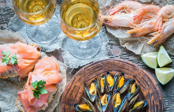 Frutti di mare con due bicchieri di vino bianco sul tavolo di legno — Foto Stock