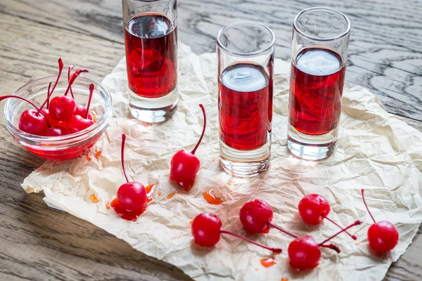 Copas de brandy de cereza con cerezas de cóctel — Foto de Stock