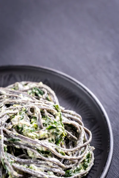 Zwarte pasta met spinazie, mascarpone en Parmezaanse kaas — Stockfoto