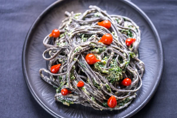 Black pasta with spinach, mascarpone and Parmesan — Stock Photo, Image