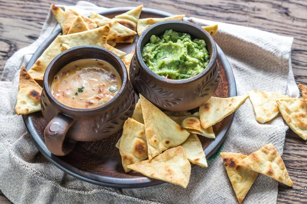 Bowls of guacamole and queso with tortilla chips — Stock Photo, Image