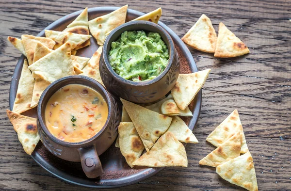 Bowls of guacamole and queso with tortilla chips — Stock Photo, Image