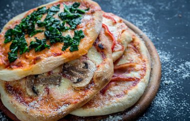 Ahşap tahta üzerinde çeşitli soslar ile mini pizza