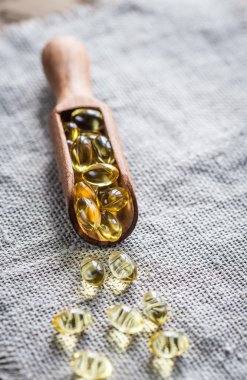 Omega-3 kapsül içinde ahşap Kepçe