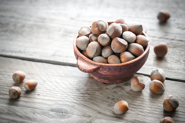 Rustic bowl of hazelnuts on the wooden table — Stock Photo, Image