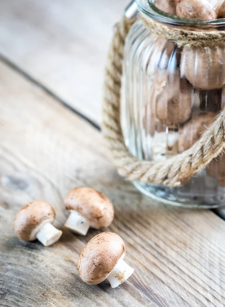 Brown champignon mushrooms on the wooden background — Stock Photo, Image