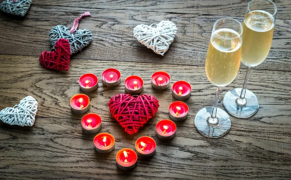 Zwei Gläser Champagner mit brennenden Kerzen und Rohrherzen — Stockfoto